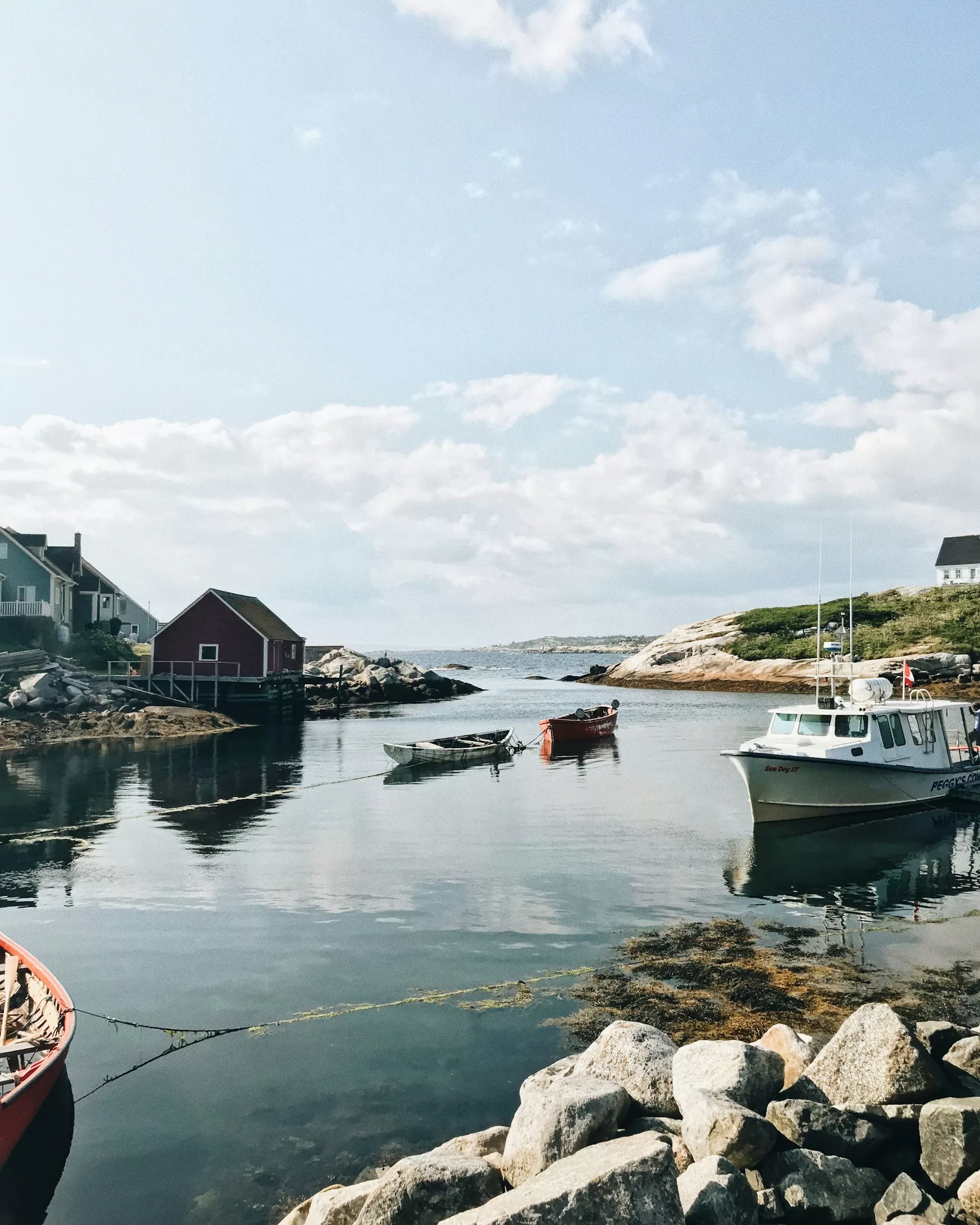 Boten in de haven van Peggy's Cove en huizen langs het water, Nova Scotia