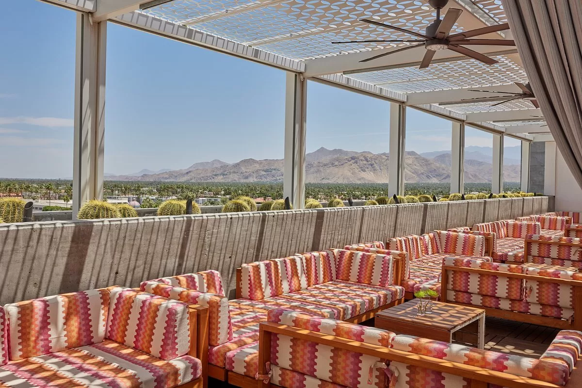 Terras met loungebanken bij het Hotel Kimpton Palm Springs met uitzicht over de bergen