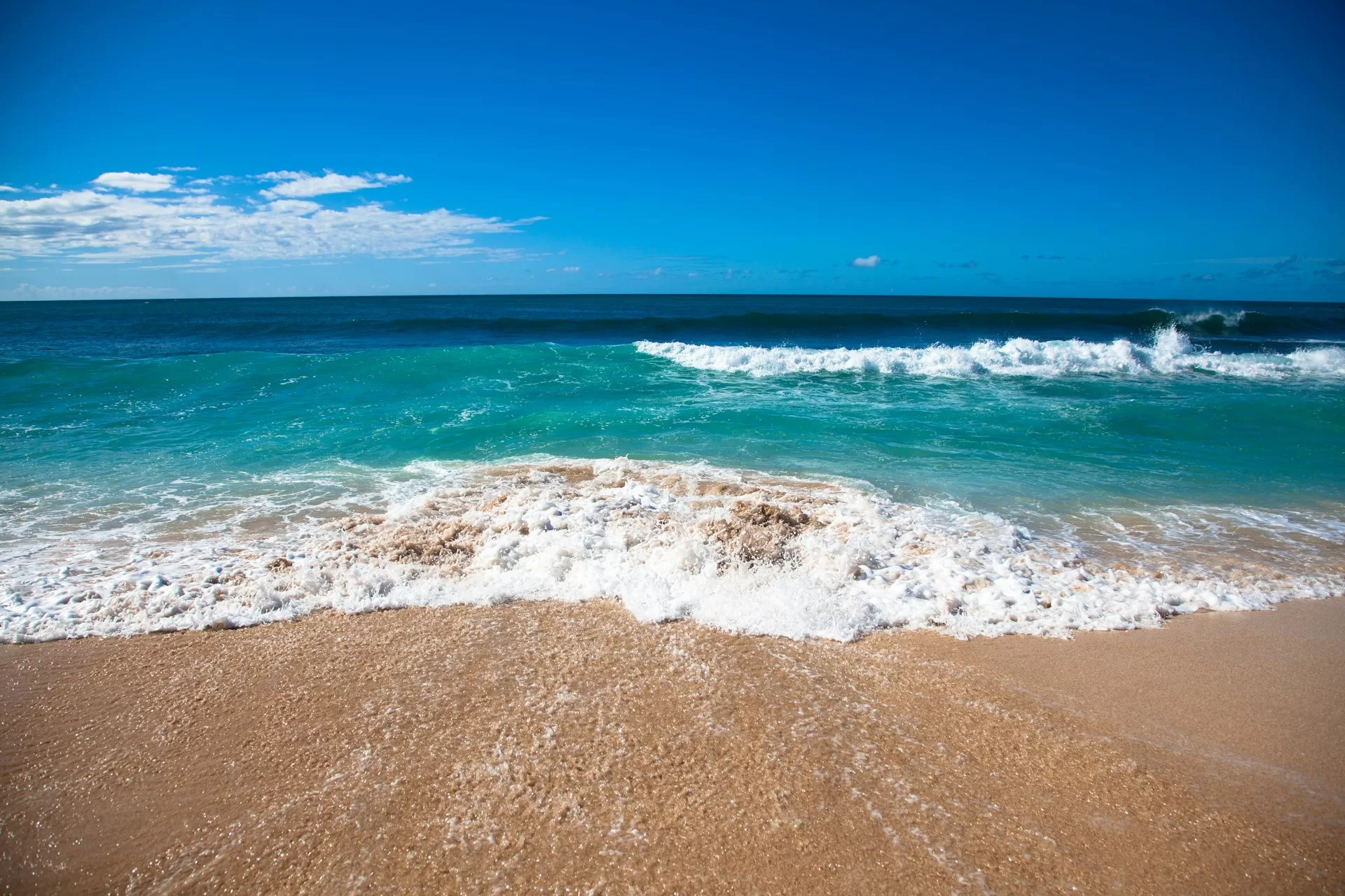 Golven in het helderblauwe water aan het strand van Hawaii