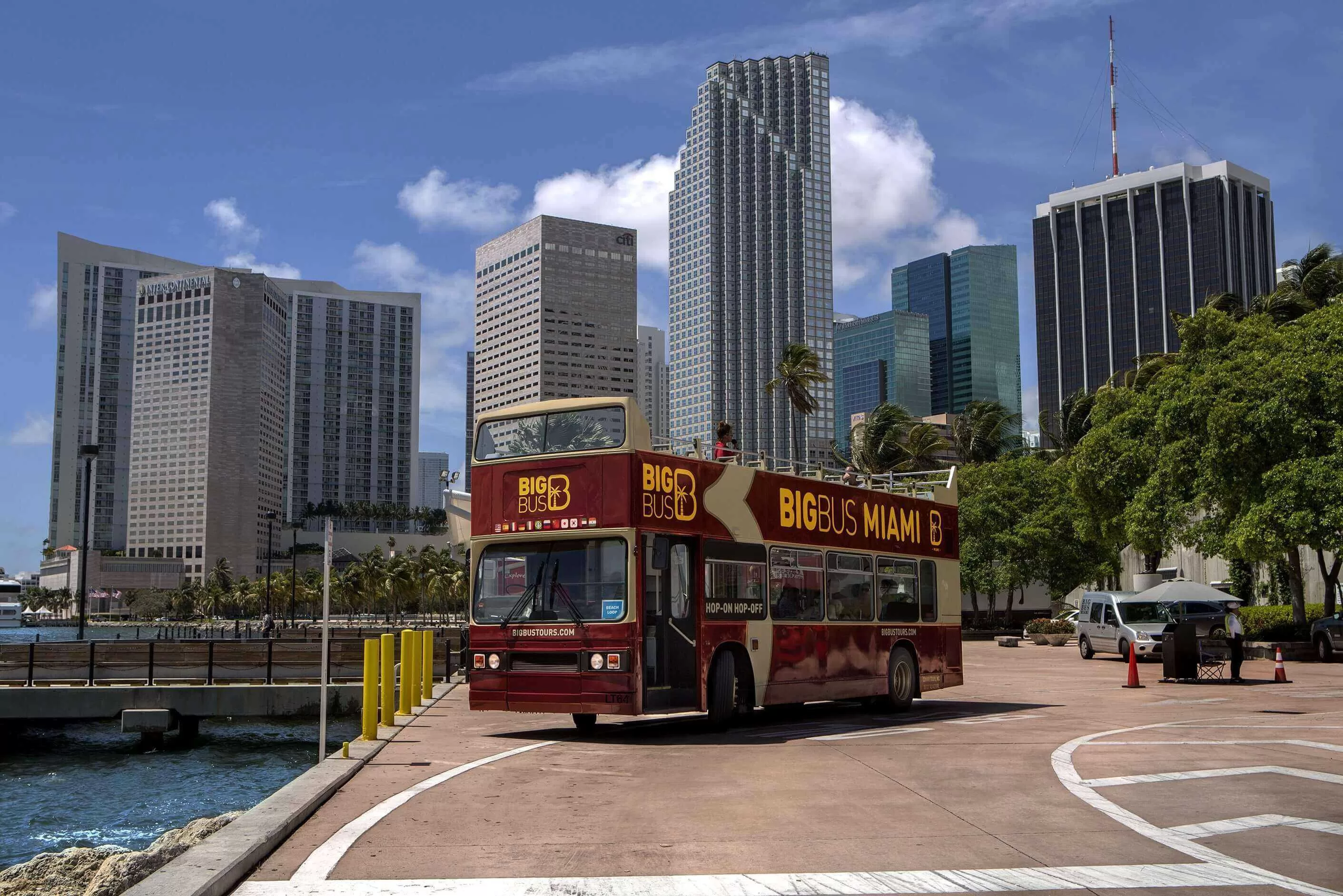 Hop-on-Hop-off-Bus in Miami mit hohen Wolkenkratzern im Hintergrund an einem sonnigen Tag