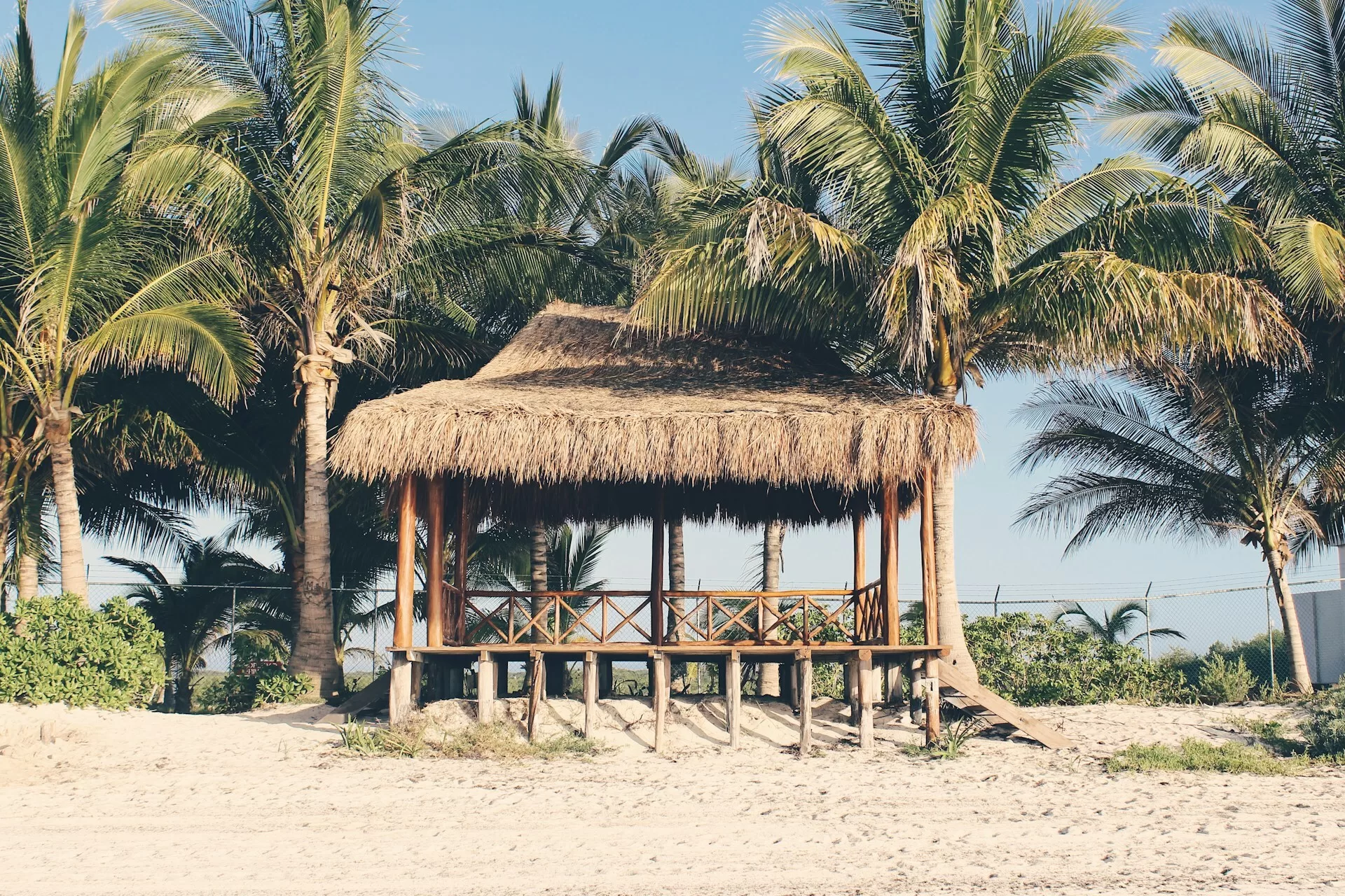 Houten plateau met rieten dak tussen de palmen op het strand van Playa del Carmen, Mexico