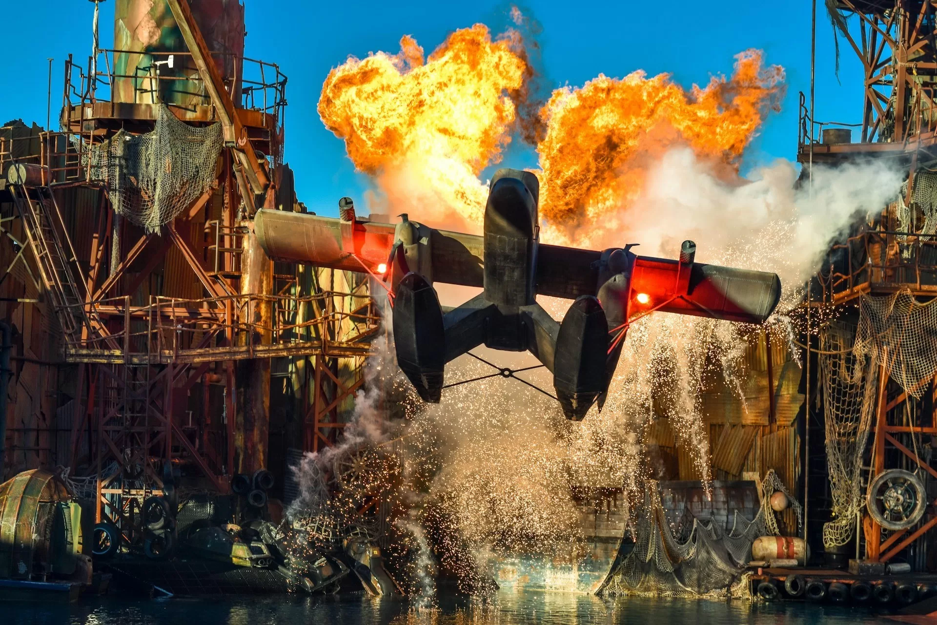 Flugzeug im Vordergrund während einer Action-Show mit Feuer und Explosionen im Hintergrund in den Universal Studios