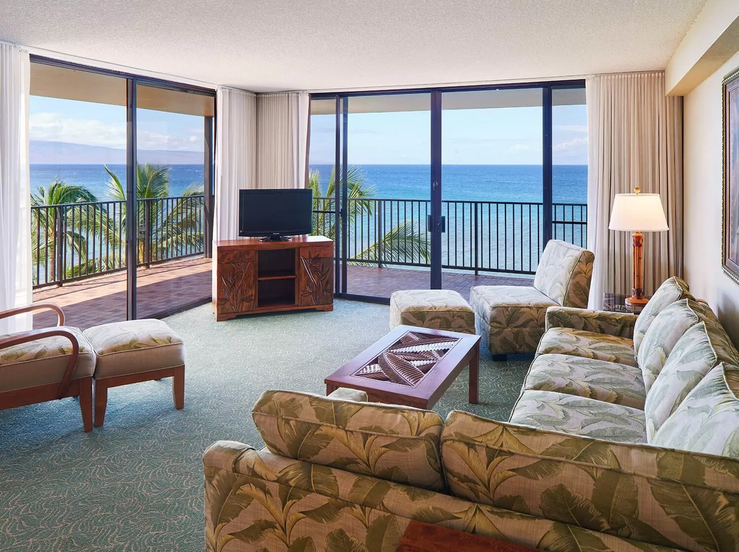 Woonkamergedeelte in een hotelkamer met balkon en uitzicht op zee