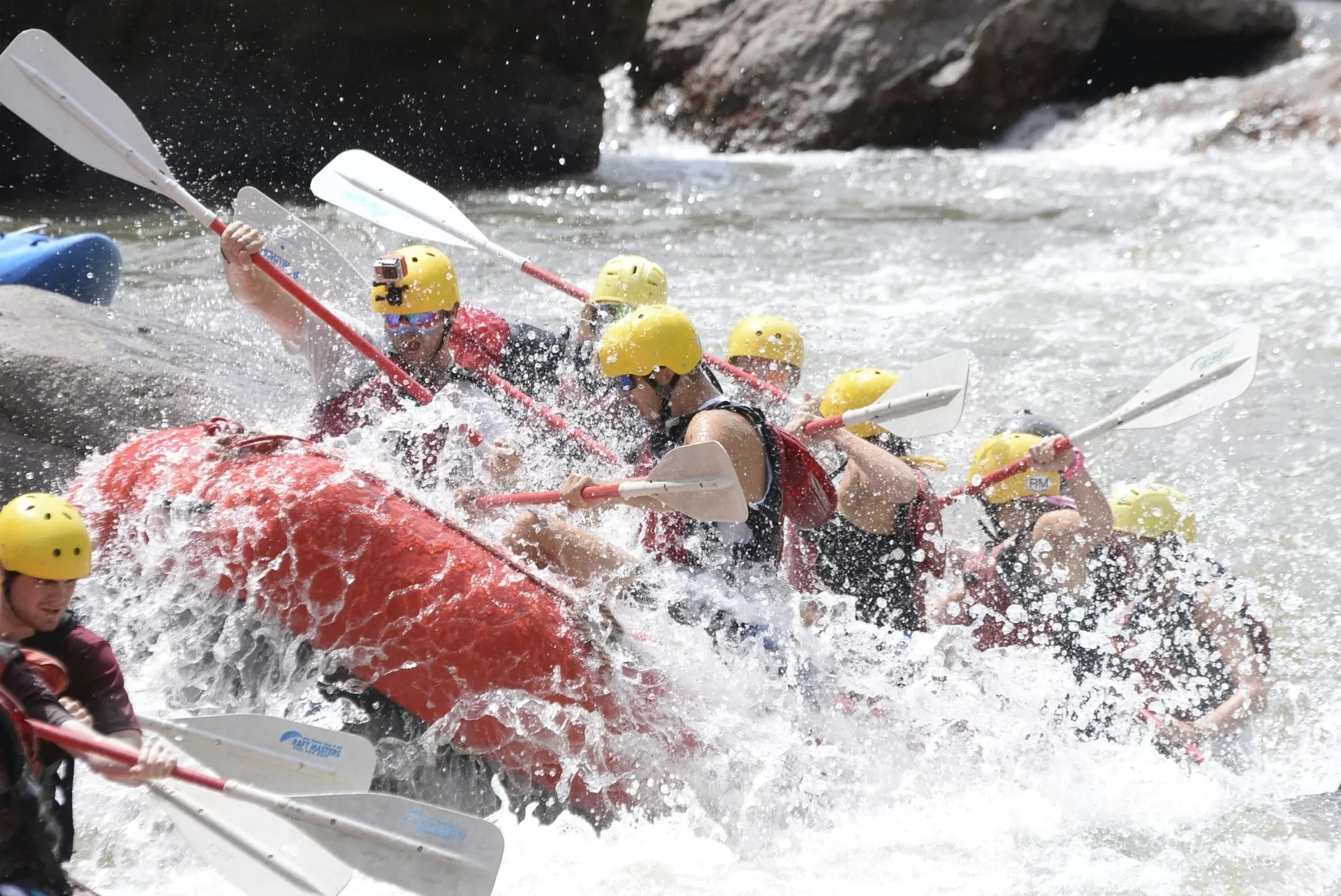 Menschen in orangefarbenen Booten beim Rafting auf dem zerklüfteten Colorado River