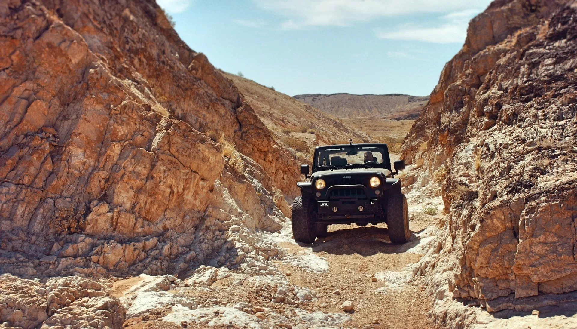 Zwarte Jeep op de Slickrock in Utah, offroad rijden over rode rotsformaties