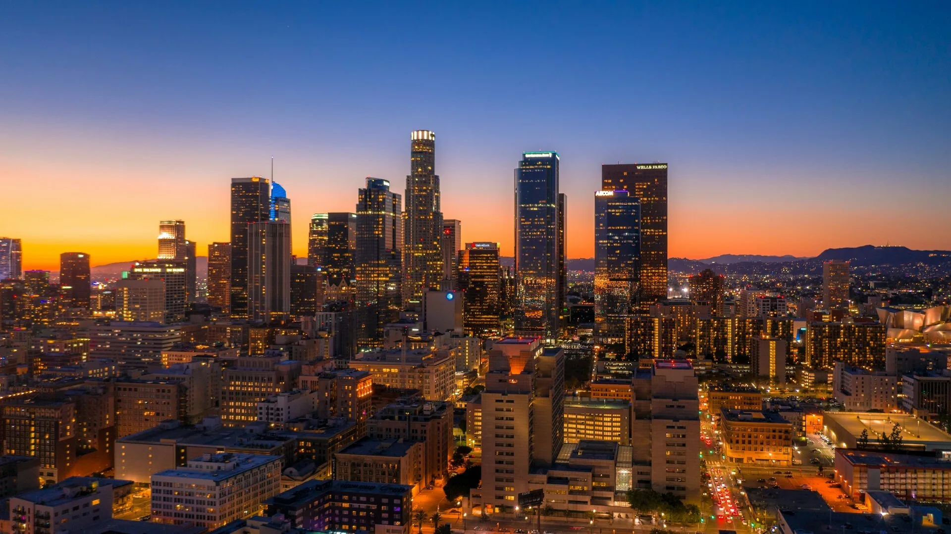 De skyline van Los Angeles met ondergaande zon op de achtergrond