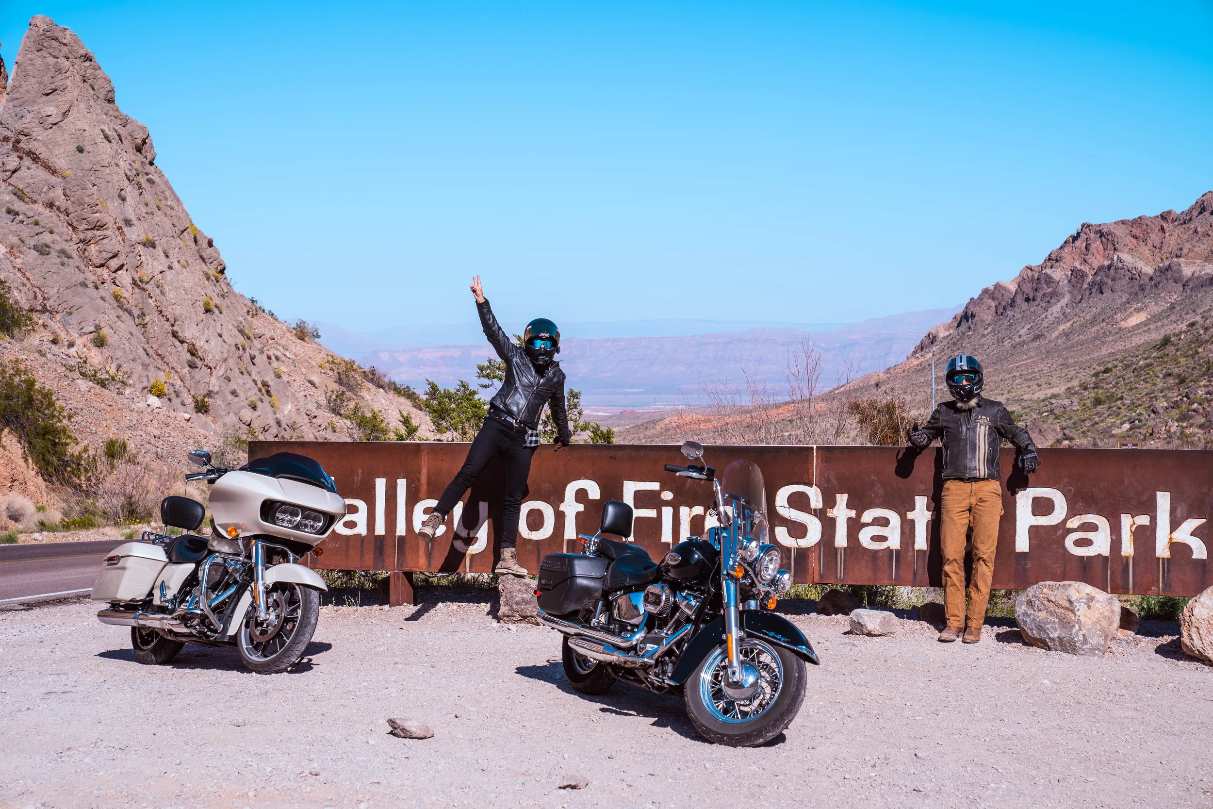 Motorrijders poserend voor het bord van Valley of Fire State Park