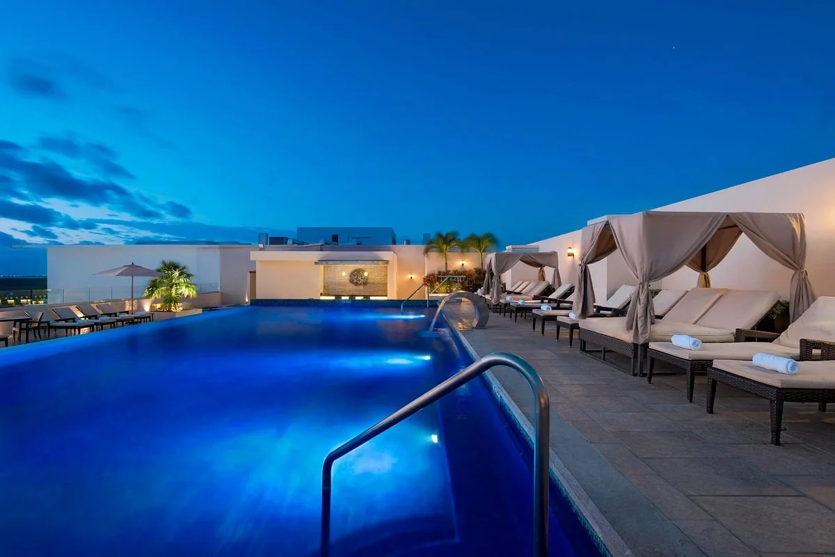 Buitenzwembad met loungestoelen en cabana's bij het Hotel Four Points by Sheraton Cancun