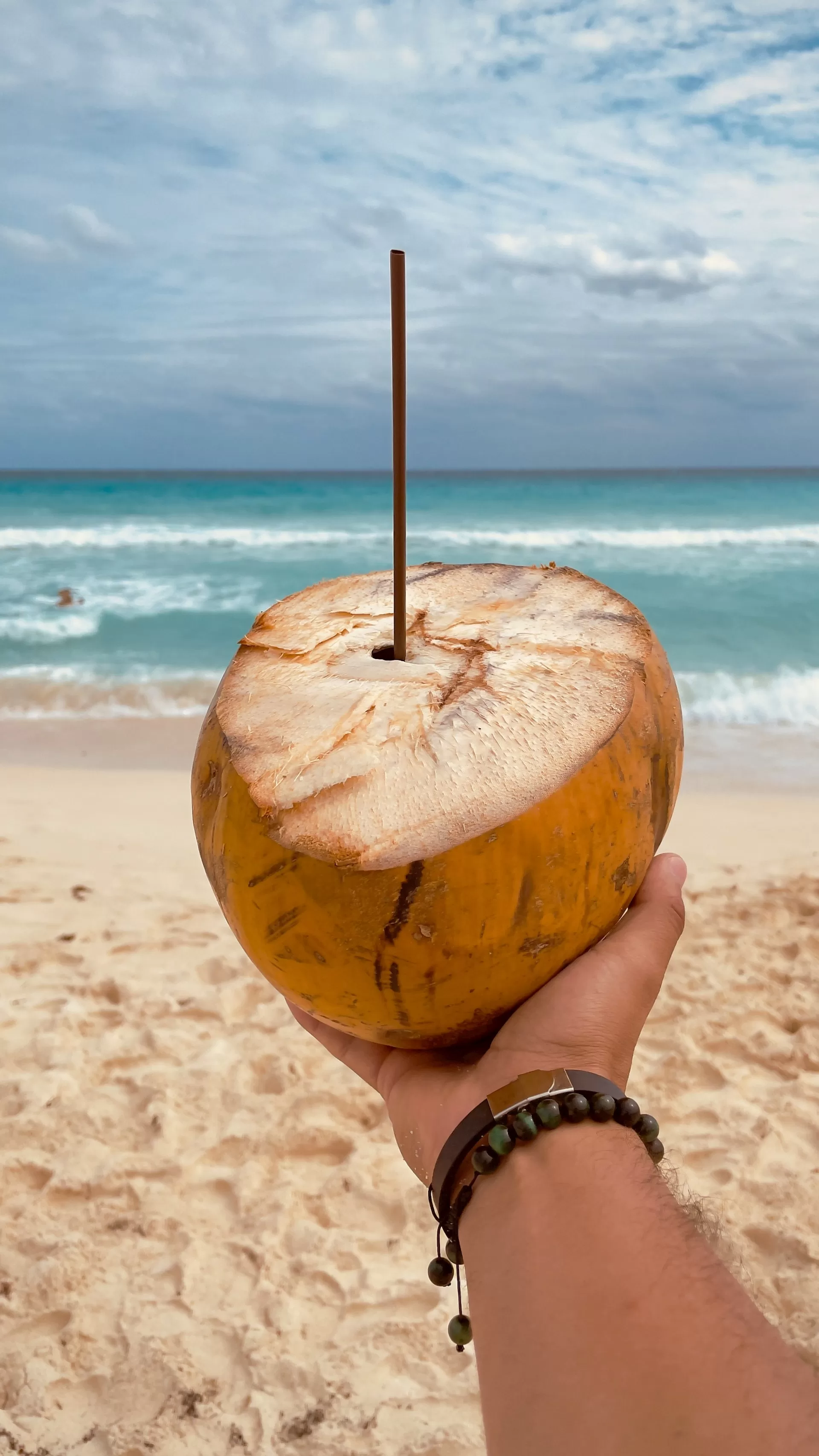 Een kokosnoot met de zee op de achtergrond in Playa Delfines, Mexico