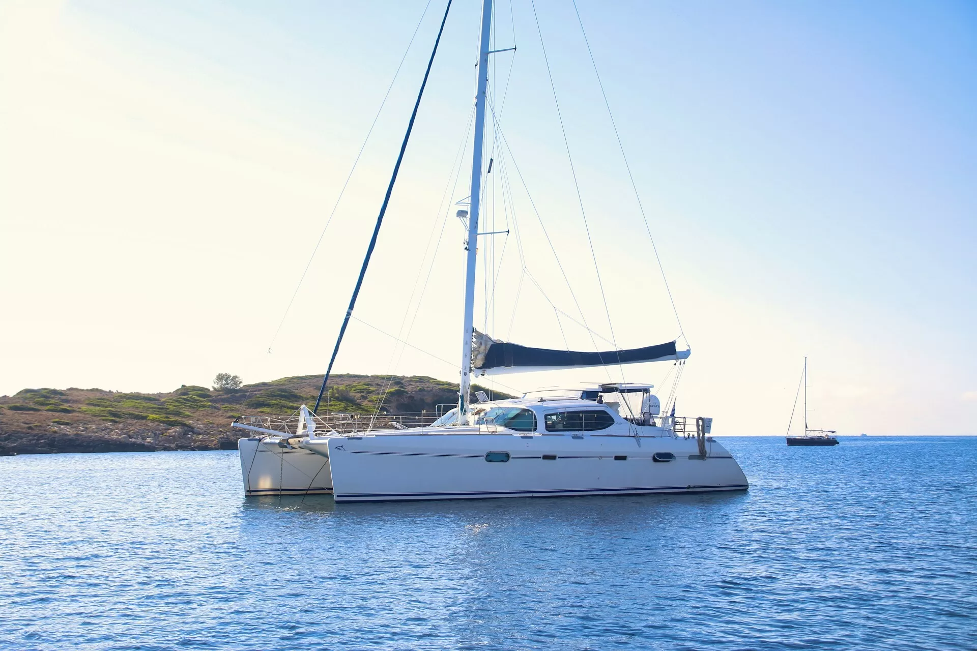 Catamaran op het water met eiland op de achtergrond