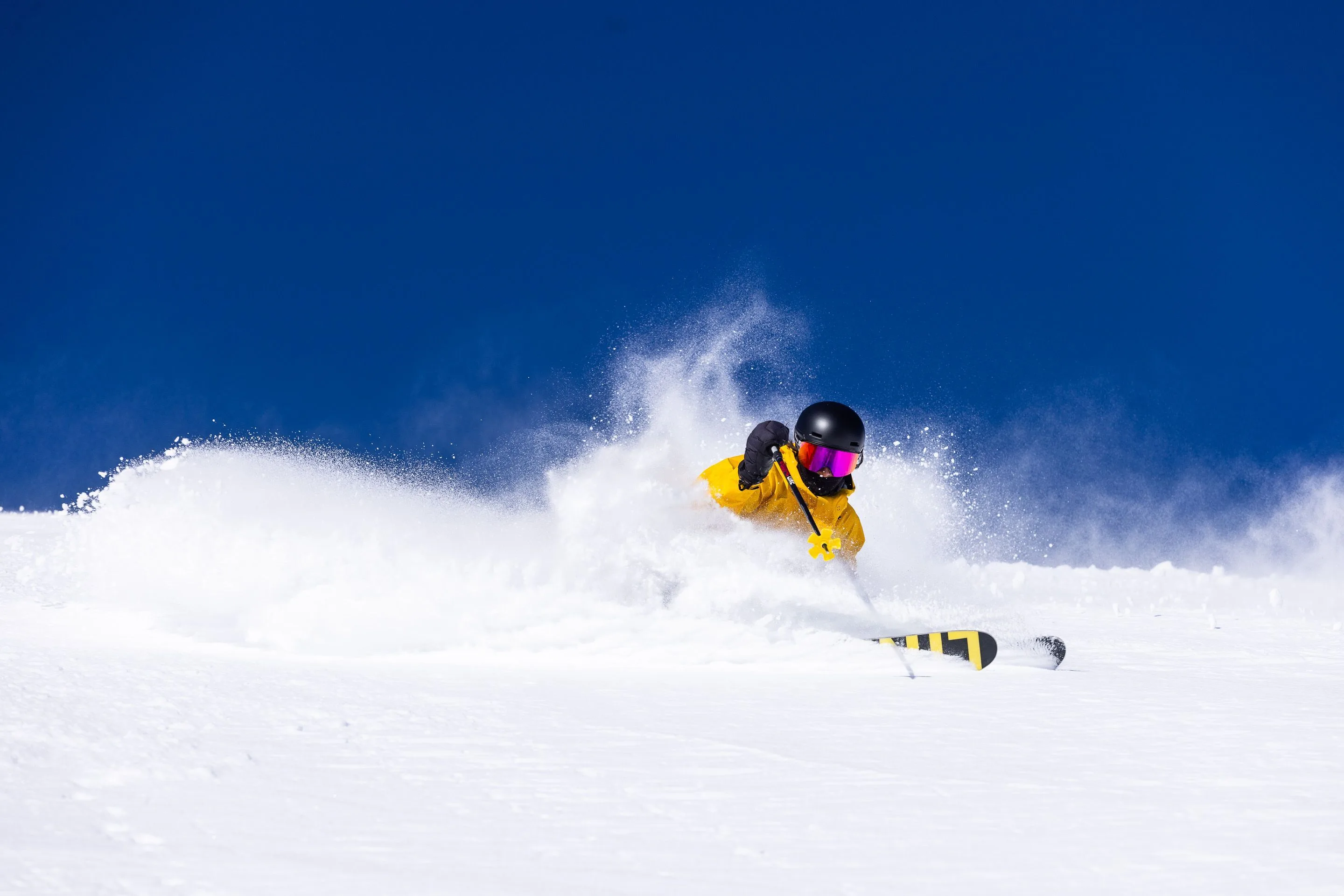 Iemand skiën in Alta met een heldere blauwe lucht op de achtergrond