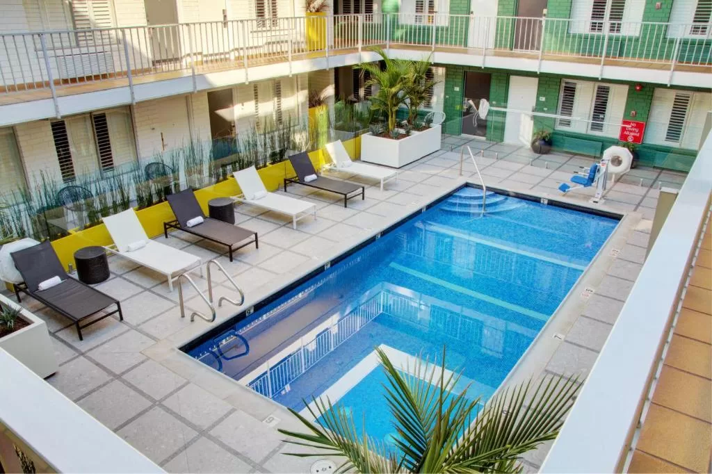 Buitenzwembad met ligbedjes bij het Adler a Hollywood Hotel