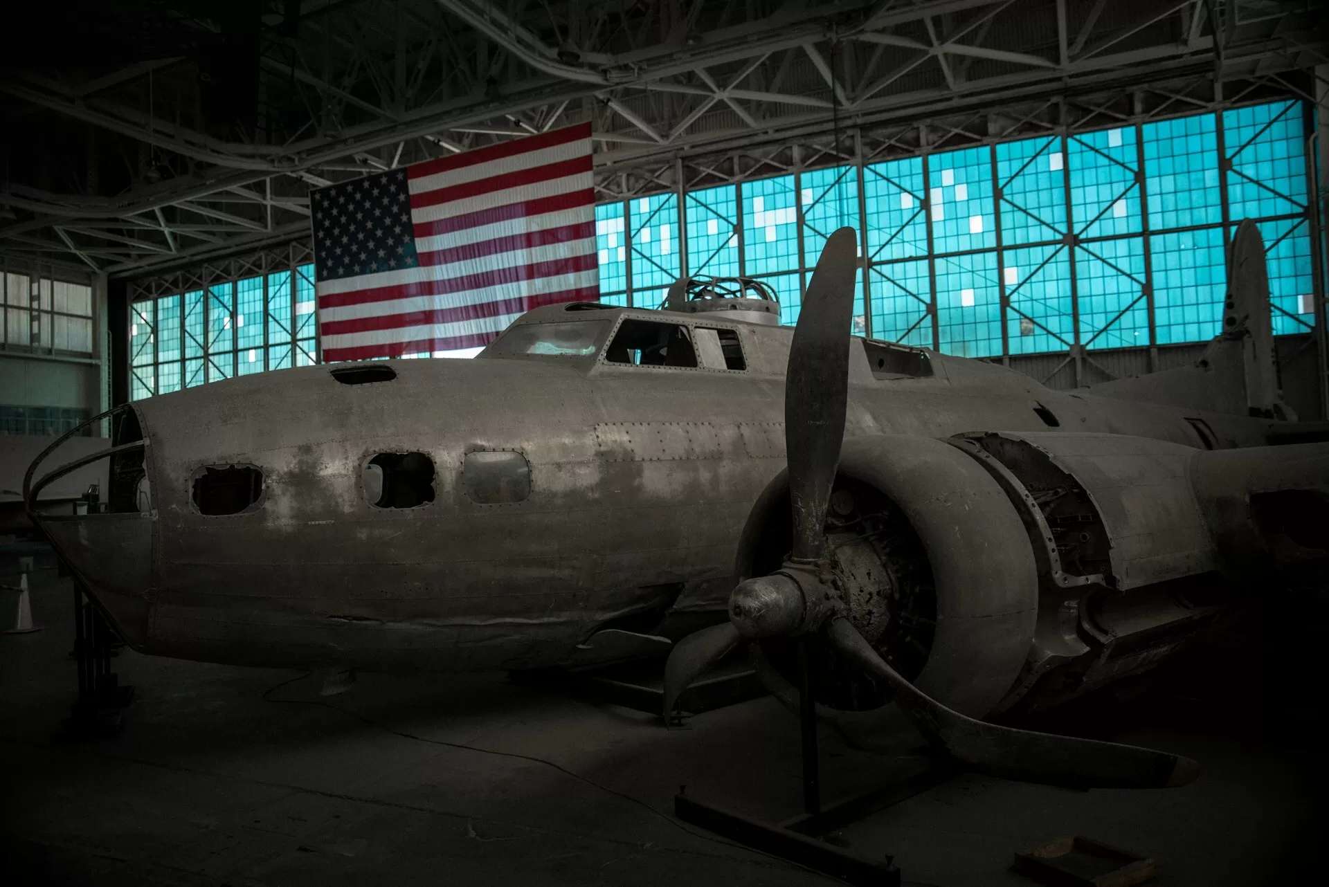 Vliegtuigwrak in het Pearl Harbor Aviation Museum met Amerikaanse vlag op de achtergrond, Hawaii, VS