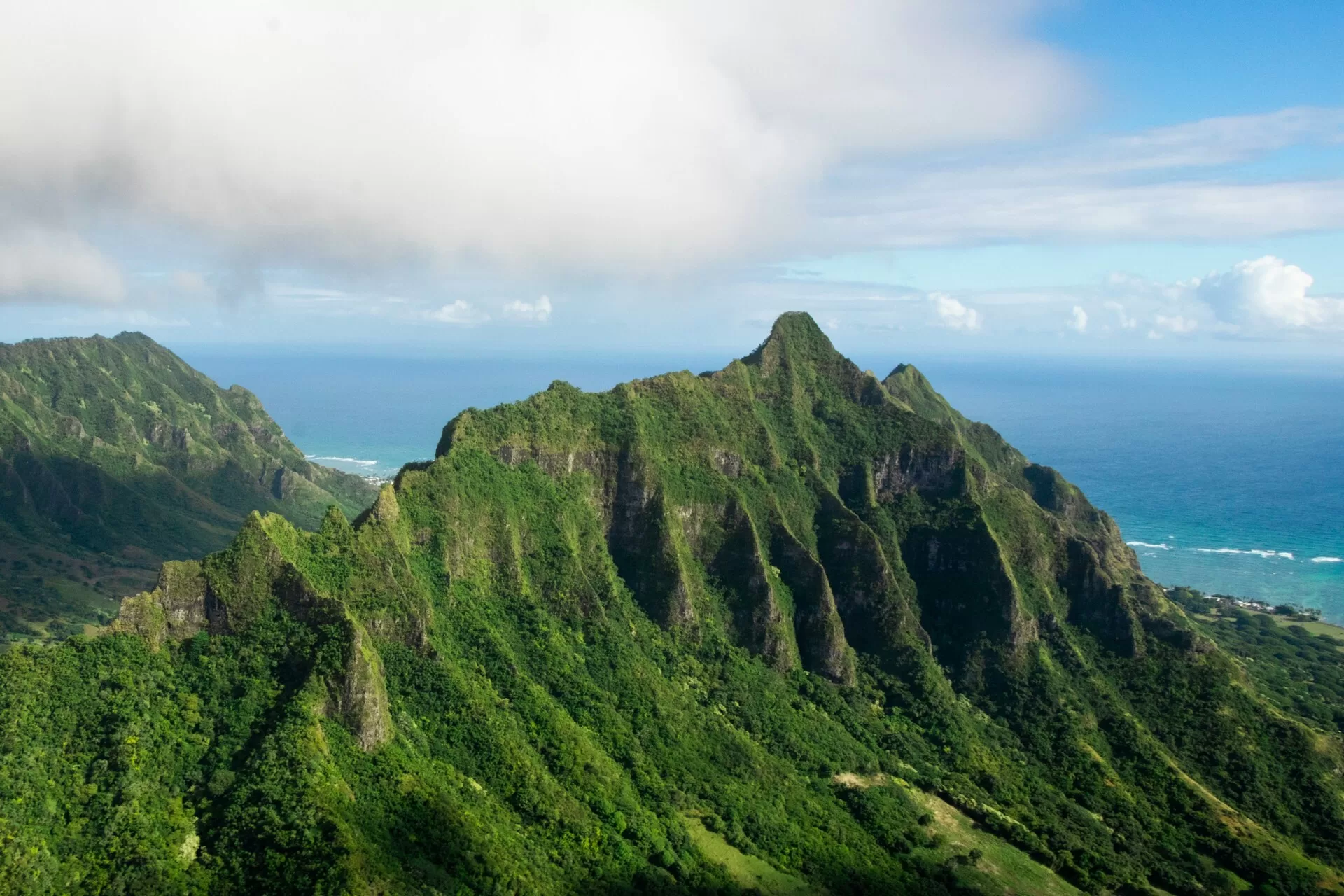 Kualoa Ranch auf Oahu, Hawaii, mit üppigem Grün und dem Meer im Hintergrund