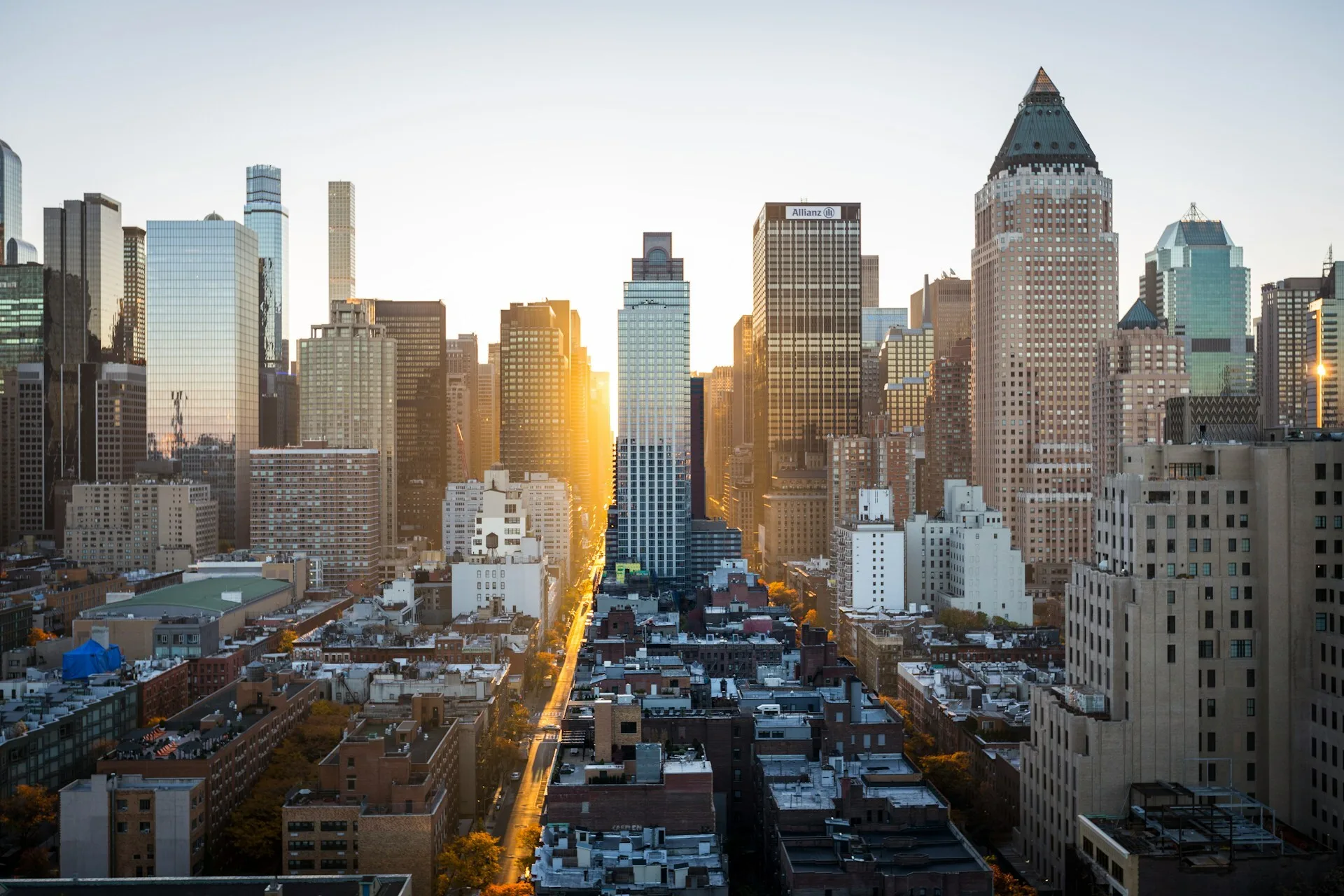 Blick auf New York bei Sonnenuntergang, mit Skyline und warmem Licht zwischen den Gebäuden
