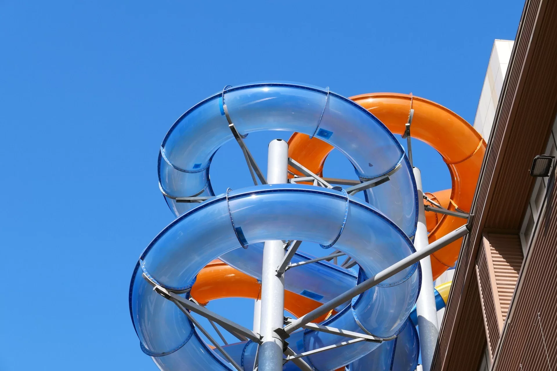 Blauwe en oranje waterglijbanen in Aquatica, vanuit laag standpunt omhoog gefotografeerd