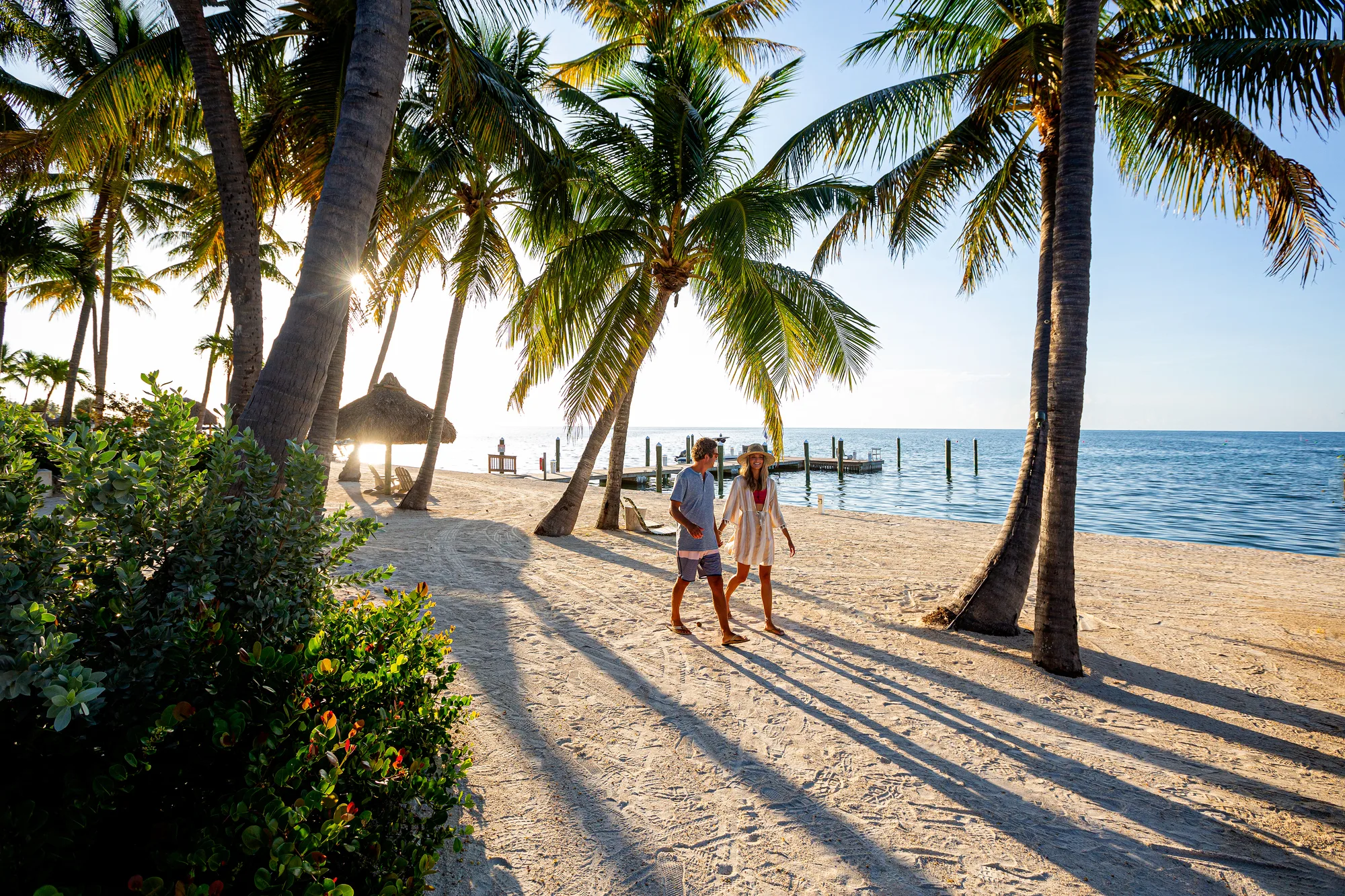 Stelletje op palmenstrand van Islamorada met ondergaande zon op de achtergrond.