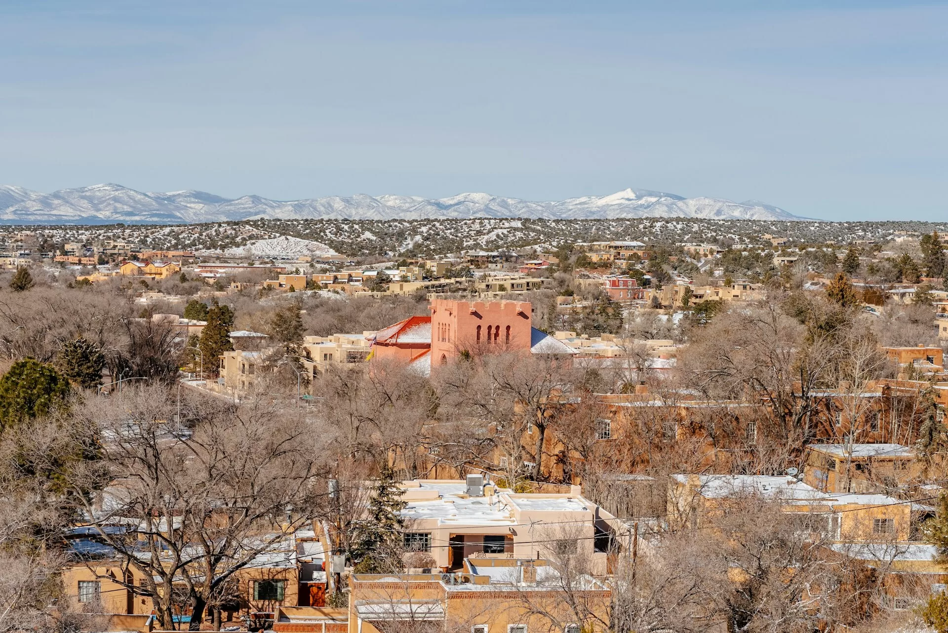Gekleurde huizen in Santa Fe met besneeuwde bergen op de achtergrond