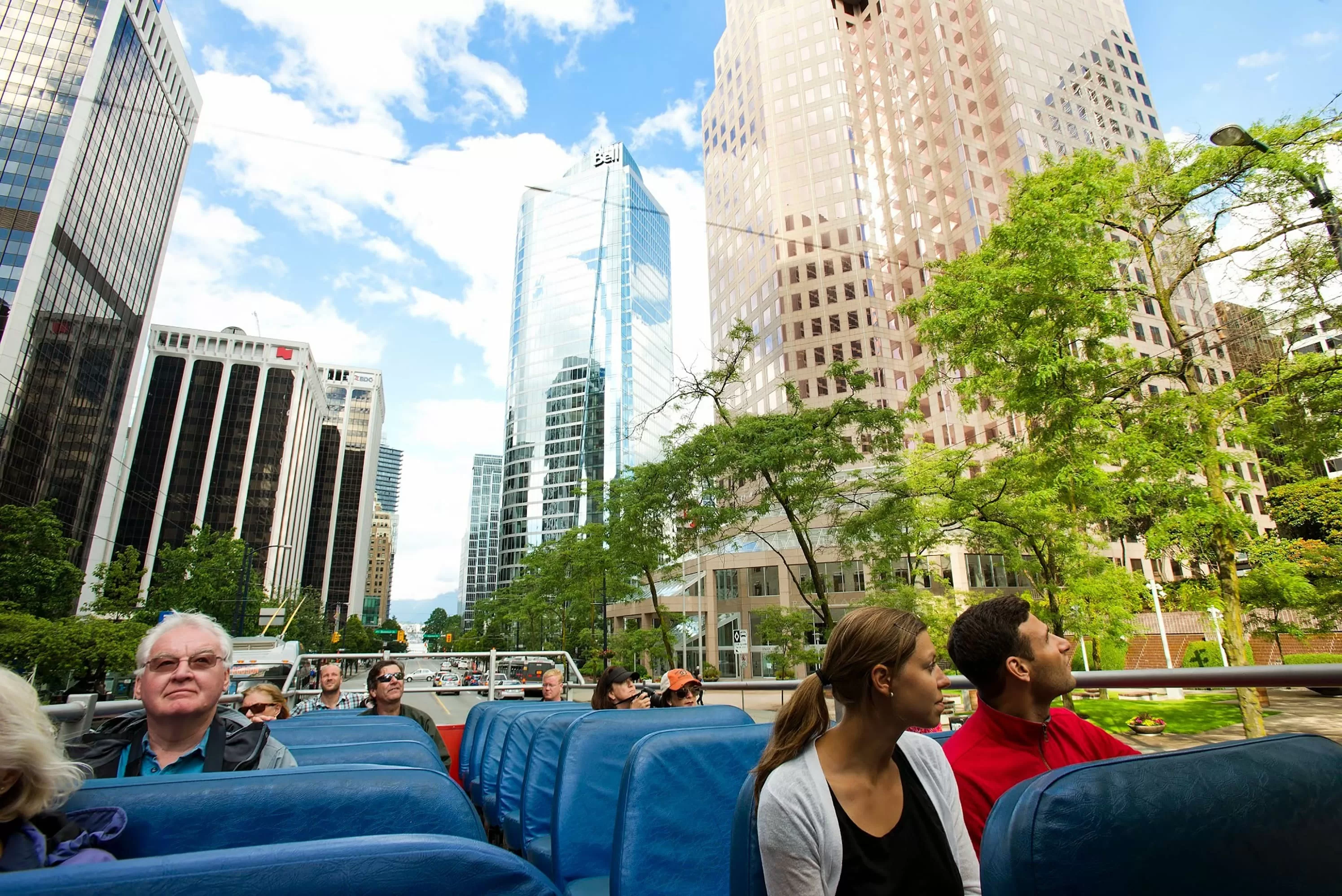 Hop-on-Hop-off bus tour in Vancouver met toeristen die bezienswaardigheden verkennen in een open dubbeldekker bus