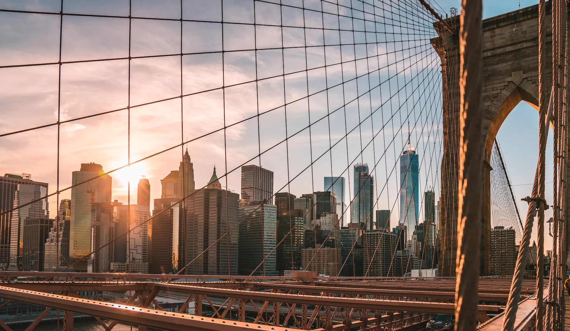 Blick von der Brooklyn Bridge auf die Skyline von Manhattan mit untergehender Sonne.
