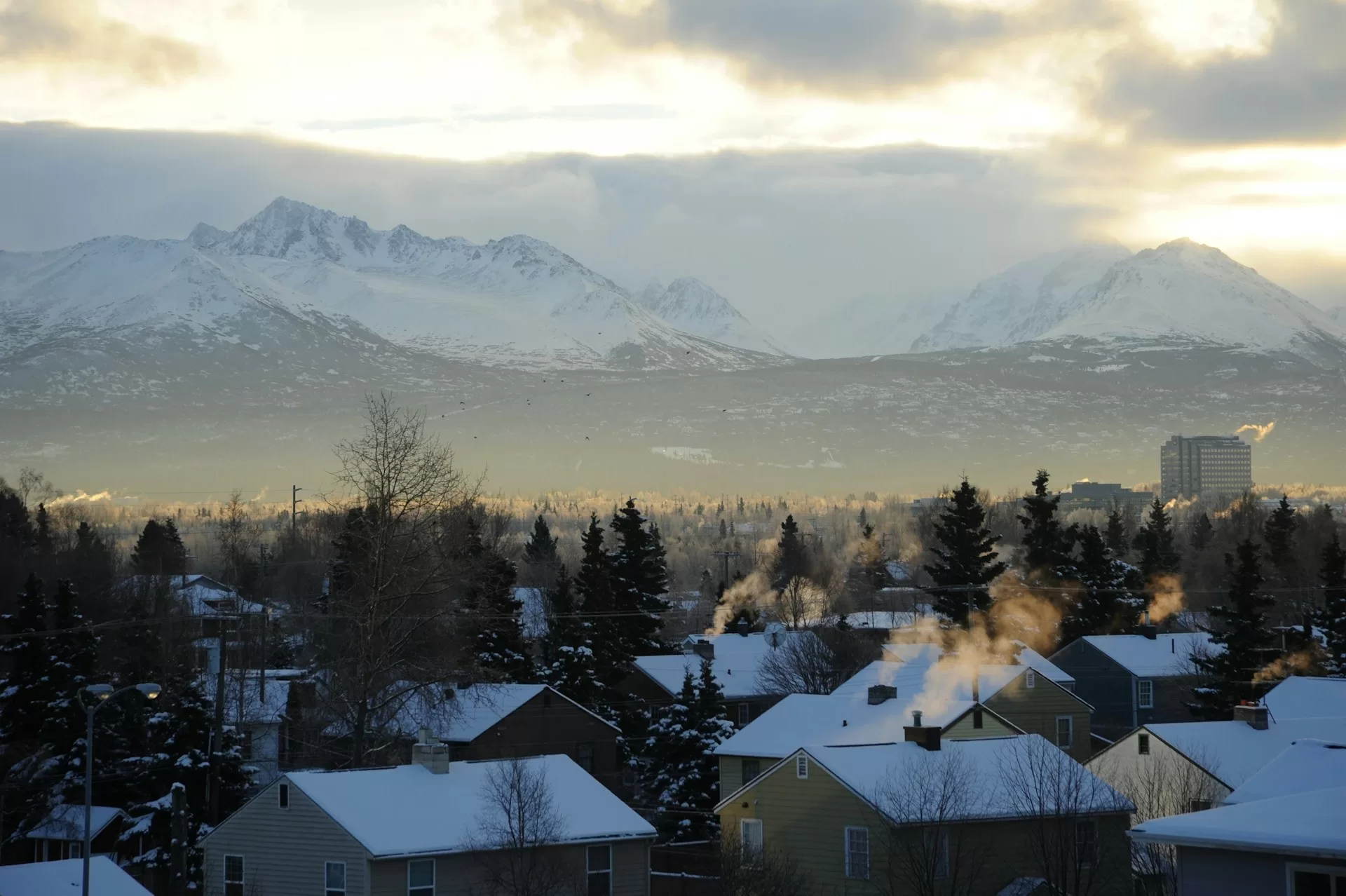 Huizen met besneeuwde daken in Anchorage met de bergen op de achtergrond
